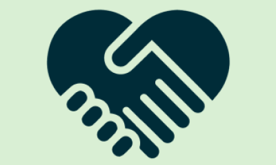 Two hands shaking in the shape of a heart.